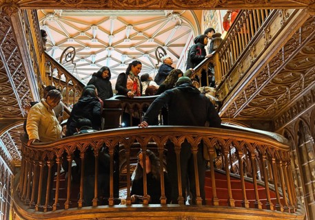 Livraria Lello, interior view of the Lello bookstore with lots of tourists on the curved wooden