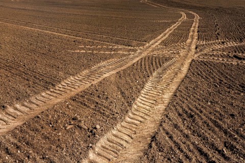 Tractor tracks, agricultural trails at a cultivated field in springtime, farmland near Wesertal,