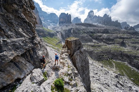 Two mountaineers in front of a picturesque mountain landscape with rocky peaks, Via Ferrata SOSAT