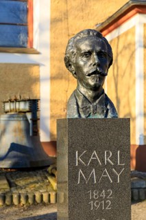 Bust of Karl May with biographical data and inscription Es sei Friede, in front of the Trinitatis