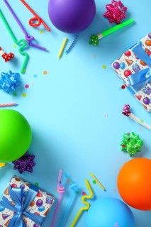 Colorful birthday party flat lay with balloons and gifts on blue background
