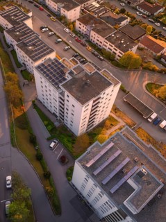 Bird's-eye view of residential buildings with parked cars and streets at sunset, urban atmosphere,