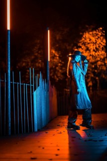 Girl in a hat walking at night in a park, pensive and enjoying the tranquility without people, blue