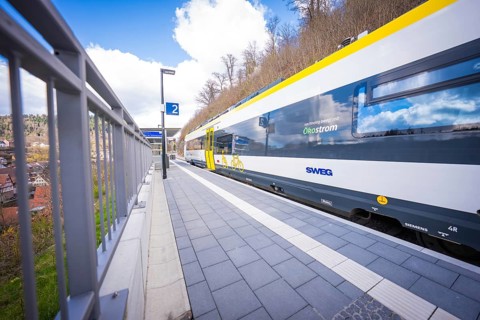 Modern regional train stands on the railway station track under clear skies, Hermann Hesse Bahn,