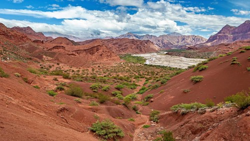 Red rocks and valleys with vegetation under a clear, blue sky, the landscape and colorful rock