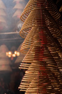 Detailed view of spiraled incense coils with red threads, symbolizing prayers and celebrations