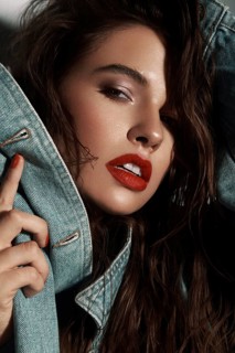Beautiful sexy girl with bright makeup, red lips, wet hair in a denim jacket. Beauty face. Photo