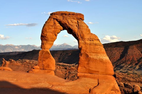 Delicate Arch rock arch shining in the light of sunset in an open desert landscape, Arches National
