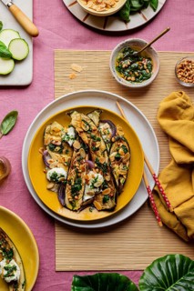 Top view of gourmet roasted courgettes topped with mozzarella, fresh basil, and toasted almonds,