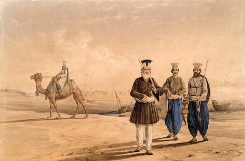 Two men and a rider riding a camel in a vast sandy landscape