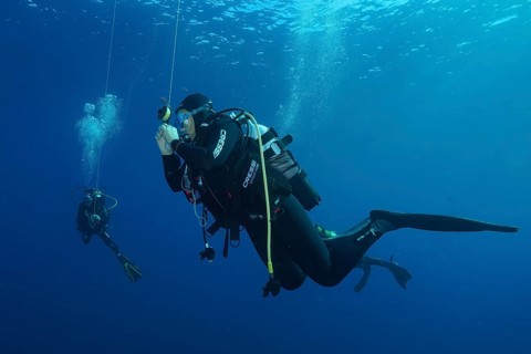 Two divers at a safety stop underwater surrounded by deep blue, Giens Peninsula dive site,