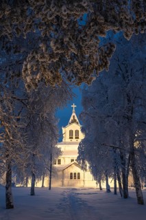 Illuminated wooden church in snow, Gällivare, Norrbotten, Lapland, Sweden, December 2023