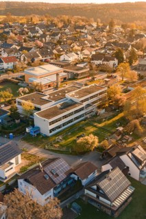 School and residential buildings with solar panels in an autumn landscape, Schlehengäuschule,