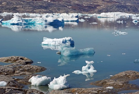 Ice floes are reflected in calm, clear water in an arctic landscape, Tiniteqilaaq, Tasilaq,