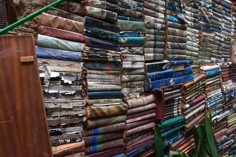 Stacked books on a wall after flood damage in a bookstore, Venice, Veneto, Italy