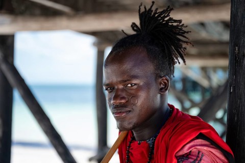 MICHAMVI, ZANZIBAR - OCTOBER 15, 2025: Close up portrait of a young African man in traditional red