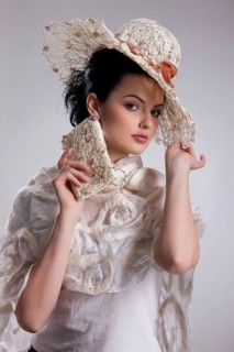 Young attractive woman dressed in fashionable handmade clothing on isolated background