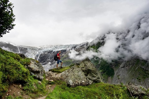 Mountaineers on a hiking trail, cloudy mountain landscape with Grindelwald-Fiescherfirn glacier,