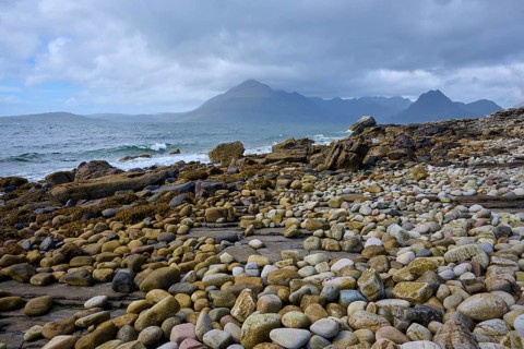 Pebble beach with waves, view of mountains in background and cloudy sky, Elgol Beach, Elgol, Isle