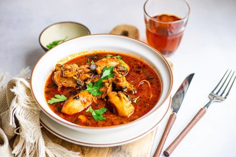 Traditional Georgian chicken stew, known as chakhokhbili, cooked in a rich tomato sauce with
