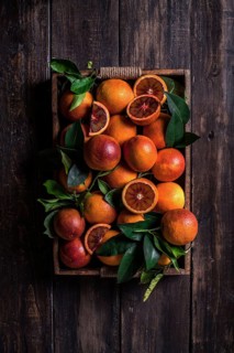 Top view a tray with sanguine and green leaves on a wooden table