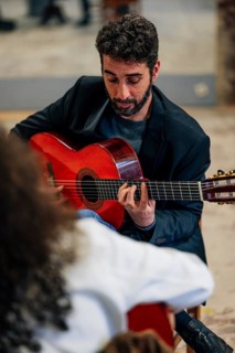 From above male friends playing guitars at table in music studio