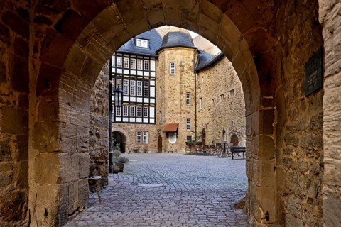 Historic inner courtyard with stone archway and half-timbered house, ambience of old times, The