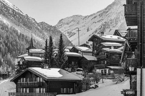 Snow-covered old farmhouses, large wooden cross, black and white photo, historic town center,
