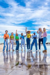 Vertical photo of a multiracial group of spontaneous young people dancing together outdoors