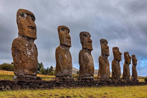 Moai statues on Easter Island rising out of a grassland into the cloudy sky, The Moai statues on