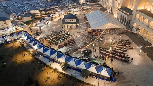 Aerial view captures hundreds of Muslims gathered at long tables for a communal Iftar meal in a