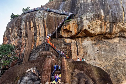 People climb a steep path nestled in a majestic rocky landscape, The Lion Rock near Sigiriya in Sri