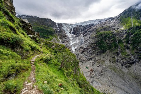 Hiking trail on a steep mountainside, cloud-covered mountain landscape with