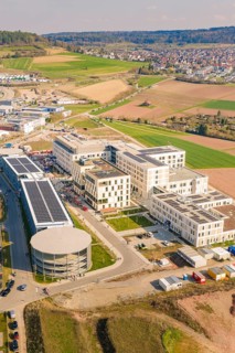 Aerial view of a modern building complex with solar system in a rural area near a city, new