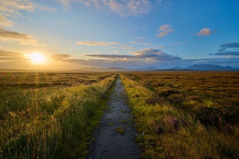 A small path stretches through a sunrise-lit landscape with cloudy skies, Moine House, Moine Track,