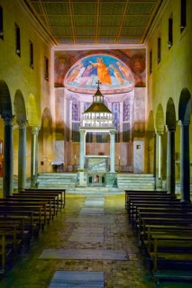 Interior view through central nave of altar and apse in three-nave flat-roofed columned basilica