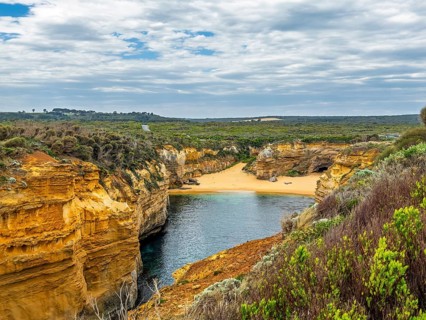 Explore this stunning coastal landscape featuring dramatic cliffs and a serene sandy beach, under a