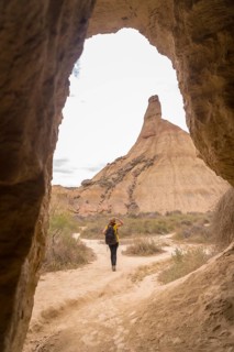 Vertical rear view of a woman walking alone in the desert through a path