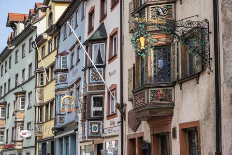 Historic town houses with artfully decorated bay windows and traditional guild signs, signs in