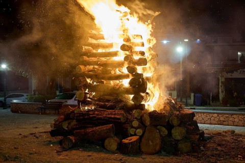 ©Udo Rein, A pile of wood is on fire in the night, with surrounding sparks and intense luminosity,