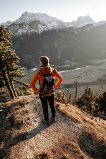 Hiker in the Allgäu at sunset in spring on the Zirmgrat near Pronten in the Allgäu