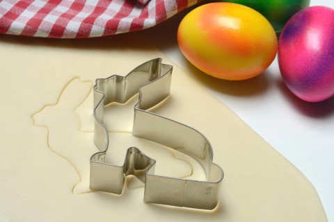 Rolled dough with bunny cookie cutter and easter eggs
