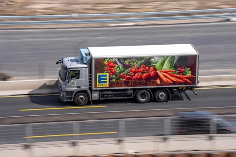 Freight truck for food logistics, on the motorway, supermarket chain EDEKA