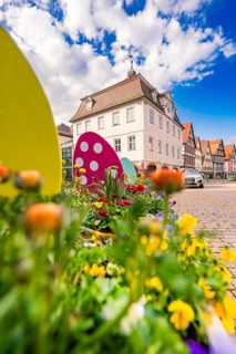 Flowers and Easter decorations in front of half-timbered houses under a lively sky, Nagold, Calw