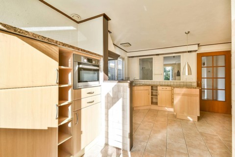 A bright and spacious modern kitchen featuring elegant cabinetry, sleek appliances, and ample
