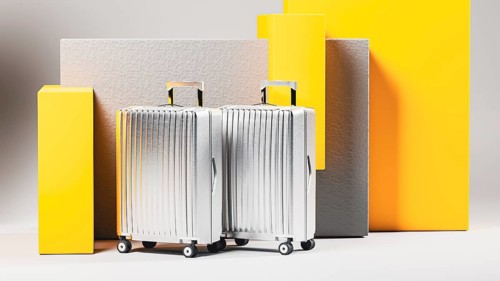A collection of shining suitcases stands against a neutral backdrop, inviting thoughts of new