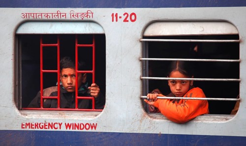 New Delhi, India, 15.01.10 - Railway station in New Delhi, a boy and a girl looking out of a train