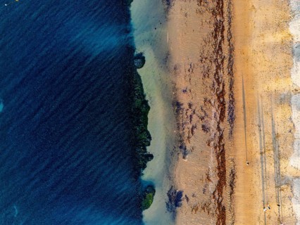 Aerial view of a coastline showcasing turquoise ocean water meeting sandy beach in the Great Ocean
