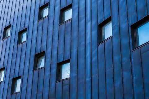 A contemporary building showcasing a multicolored facade, emphasized by a pattern of blue-tinted