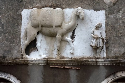 Historical relief with Moorish merchant and camel on the façade of a palazzo, Venice, Veneto, Italy